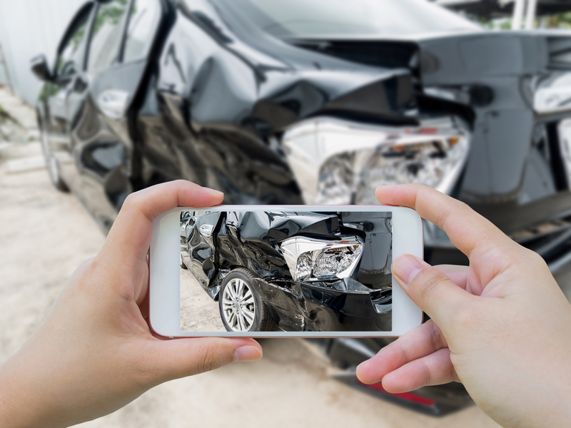 A person captures a picture of his car wreck due to a car accident.