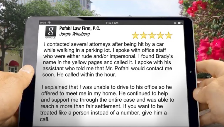 A person holding an iPad reading a five star review of Pofahl Law Firm, P.C. for a job well done on another pedestrian accident case.