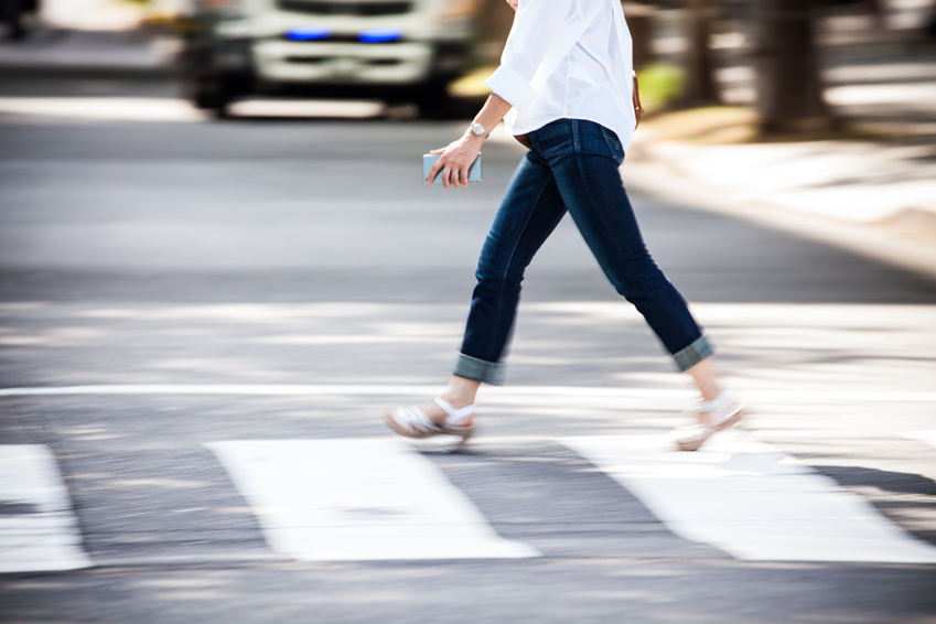 A person is crossing the pedestrian in a fast pace that may result a pedestrian accident if not careful.
